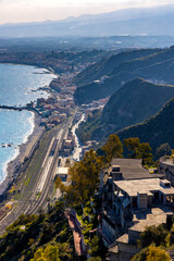 Panoramic view of Taormina shore at Ionian sea with Giardini Naxos and Villagonia towns and Mount Etna volcano in Messina region of Sicily in Italy - 747807202