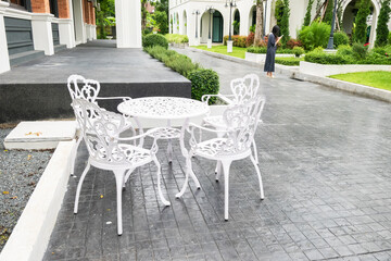 Classic white steel chair and table in the garden,empty white vintage chairs in the garden,decoration english garden concept. - obrazy, fototapety, plakaty