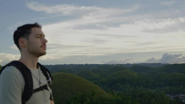 Explorer man walking by Bohol chocolate hills in the Philippines