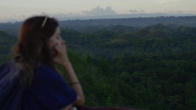 Out of focus young woman contemplating Bohol chocolate hills in the jungle