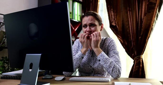 Worried businesswoman looking at computer screen and biting her nails 4k movie slow motion. Stress at work concept