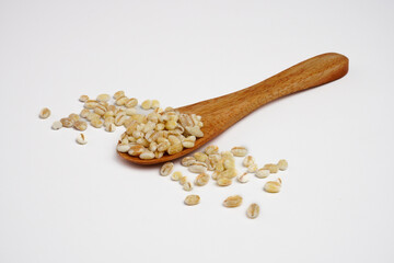 Pearl barley grain seeds in a wooden spoon concept background