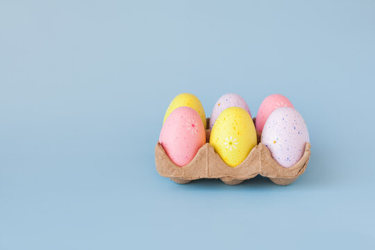 Eco basket with colorful easter eggs on pastel light blue background. minimalistic decoration, minimal composition. Front view, place for text, banner