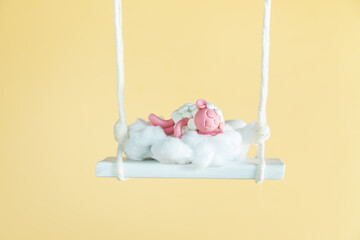 Cute plasticine sheep sleeps on a swing. Good night sweet dreams.