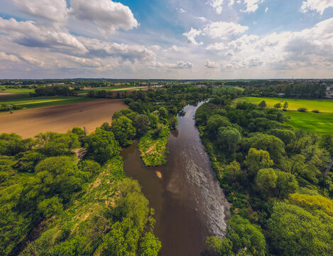 green fields and meadows, the prona river, spring on a beautiful sunny day. Idyllic landscape from a drone