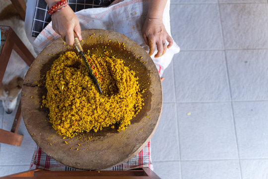 Raw Spices or in Balinese called Bumbu Megenep Being Chopped on a Wooden coaster with Blakas or Belakas, a Traditional Sharp Weapon from Bali