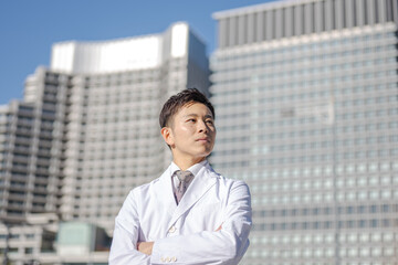 腕組みした白衣の男性