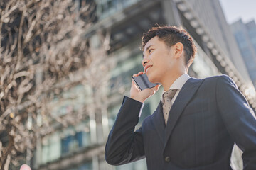 都会で電話するビジネスマン
