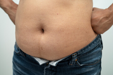 Naklejka premium Overweight Asian woman show and use hand to squeeze fat belly.