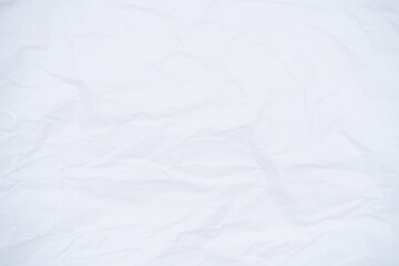 Close-up of a crumpled piece of white paper, with soft shadows creating a texture.