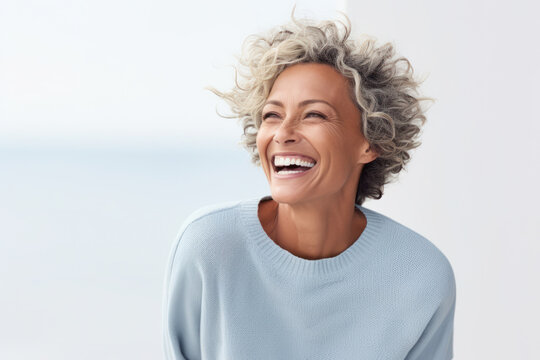 Joyful mature woman laughing in casual outfit. Happiness and wellbeing.