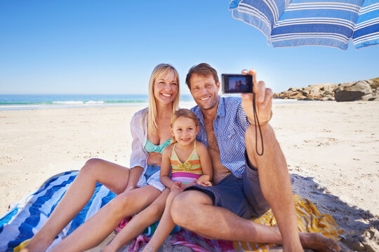 Happy family, beach and relax with selfie for photography, picture or moment in outdoor nature. Mother, father and child with smile for photo, capture or bonding memory together on the ocean coast