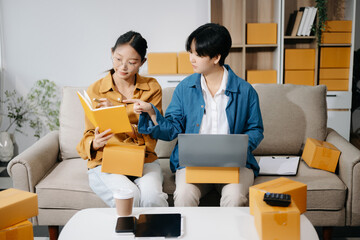 Asian young attractive couple man and woman use tablet and smartphone online shopping furniture...