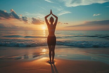 Obraz na płótnie Canvas A woman stands on the sandy beach at sunset, with waves crashing in the background, Sunset yoga session on a tranquil beach, AI Generated
