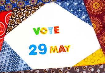 Vote 29 May on white with frame of mixed traditional South African Shwe Shwe fabric