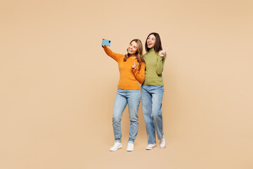 Full body young friend two women they in orange green shirt casual clothes together doing selfie...