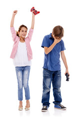 Children, siblings and winner with loser for gaming competition or esports on a white studio background. Boy and girl with smile, controller and disappointment for victory or loss on console games