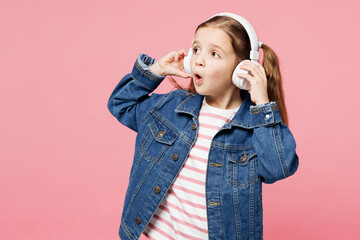 Little child shocked cute kid girl 7-8 years old wear denim shirt listen to music in headphones...