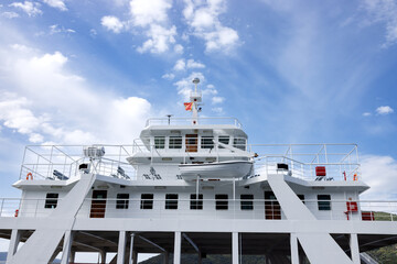 The passenger deck of the white ferry. Blue sky with white fluffy clouds. Montenegro