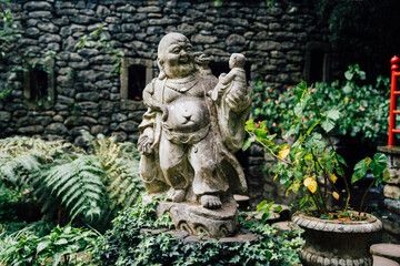 Buddhist sculpture. Botanical garden - Monte palace on spring day. Oriental part of the garden. Madeira island