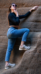 Mujer en sitio con paredes de roca y picón en la isla de Gran canaria con ropa normal de mujer...