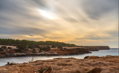 Long exposure of a cove in Formentera with fishermen's boats and cotton clouds