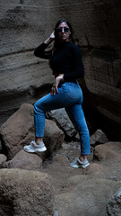 Mujer en sitio con paredes de roca y picón en la isla de Gran canaria con ropa normal de mujer...