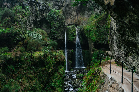 Waterfall over the hiking path of Levada Nova in Ponta do Sol. Beautiful place at the end of hike. Madeira island, Portugal.