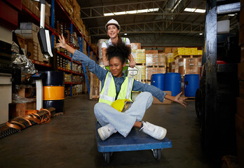 factory workers moving cart and having fun in the warehouse storage