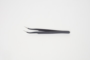 Black iron cell phone tweezers from the side on a white background