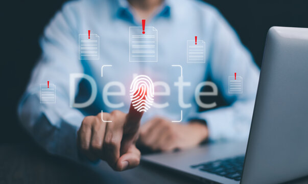 The programmer's hand is tapping on the file icon under the concept of data deletion. The concept  technology and document management.data deletion and removal