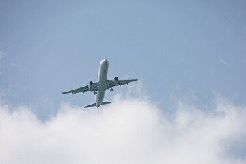 Airplane flying in sky with white clouds. Passenger plane at flight, travel concept