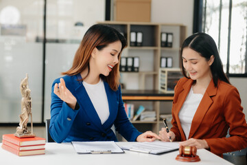Obraz premium Asian Business and lawyers discussing contract papers with brass scale on desk in office. Law, legal services, advice, justice and law concept .
