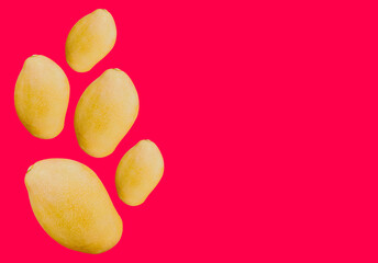 Fresh yellow mangoes on a vivid pink background with ample copy space, ideal for vibrant food...
