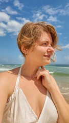 Portrait of a contemplative Caucasian woman enjoying a sunny beach day, with space for text in the...