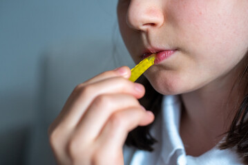 Schoolgirl Eating Gummy Worms Candy: Close-Up of Mouth