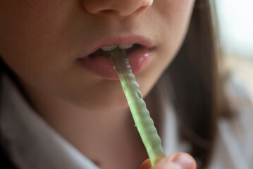 Schoolgirl Eating Gummy Worms Candy: Close-Up of Mouth