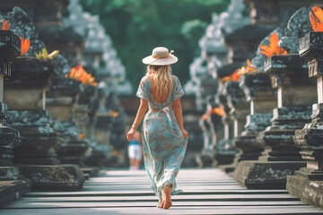 A woman in a hat strolls through a temple admiring the art
