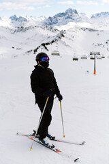 Skier in the mountains, prepared piste and sunny day. preparation for riding. vertical photo