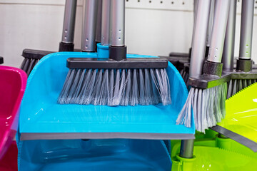 multi-colored dustpan and broom sets for cleaning in a supermarket display case