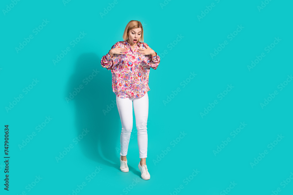 Sticker Full size photo of astonished girl wear oversize shirt white trousers look down at empty space isolated on turquoise color background