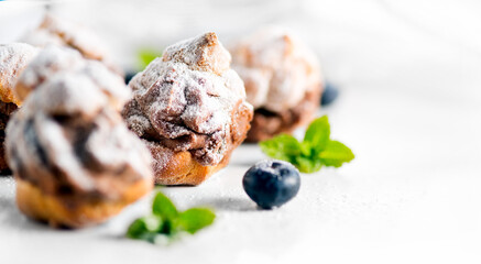 Profiterole or cream puff with filling,  powdered sugar topping with berries, isolated on white background, Fresh homemade Cream Puffs, cake, tasty French choux puff, ecler, dessert closeup. Pastries