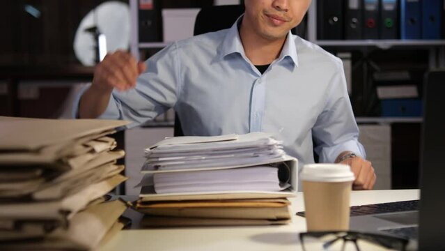 Exhausted Asian young businessman worker working on table in office.