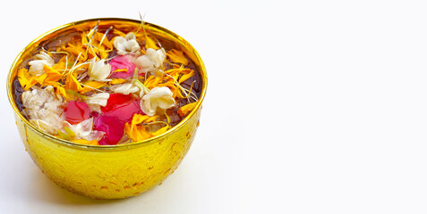 Water with jasmine flower, marigold petal and rose petal in golden bowl. Thai tradition, Songkran festival concept