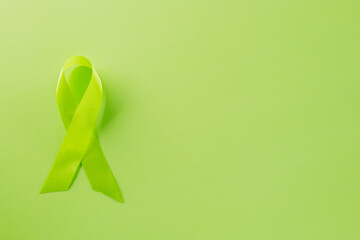 Green awareness ribbon of Gallbladder and Bile Duct Cancer month isolated on green background with copy space, concept of medical and health care support, Cancer awareness, World kidney day