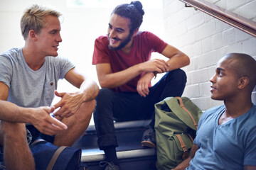 Happy man, student and friends talking on stairs with group for conversation, social interaction or chat at campus. University people or male person with smile on staircase for discussion at college