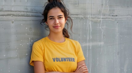 Naklejka na ściany i meble Young woman with a warm smile wearing a yellow t-shirt with the word 'VOLUNTEER