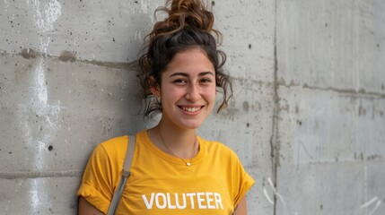 Naklejka na ściany i meble Young woman with curly hair smiling wearing a yellow t-shirt with the word 