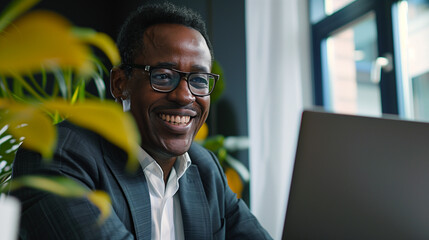 Happy african american financial mortgage advisor businessman on a virtual video call meeting with a client. Smiling black businessman working remotely from home on his laptop. Flexible work life - obrazy, fototapety, plakaty