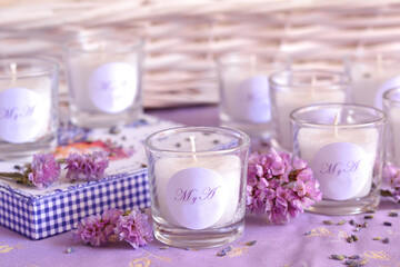 Obraz na płótnie Canvas Wedding gifts favors handmade candles with bride groom custom monogram initials letters, lilac purple lavender color, original party details, vintage shabby chic romantic style